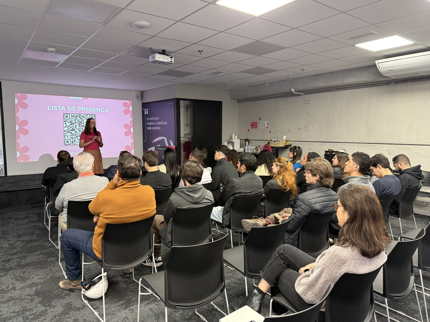 Palestrante do Instituto falando para um público atento em auditório